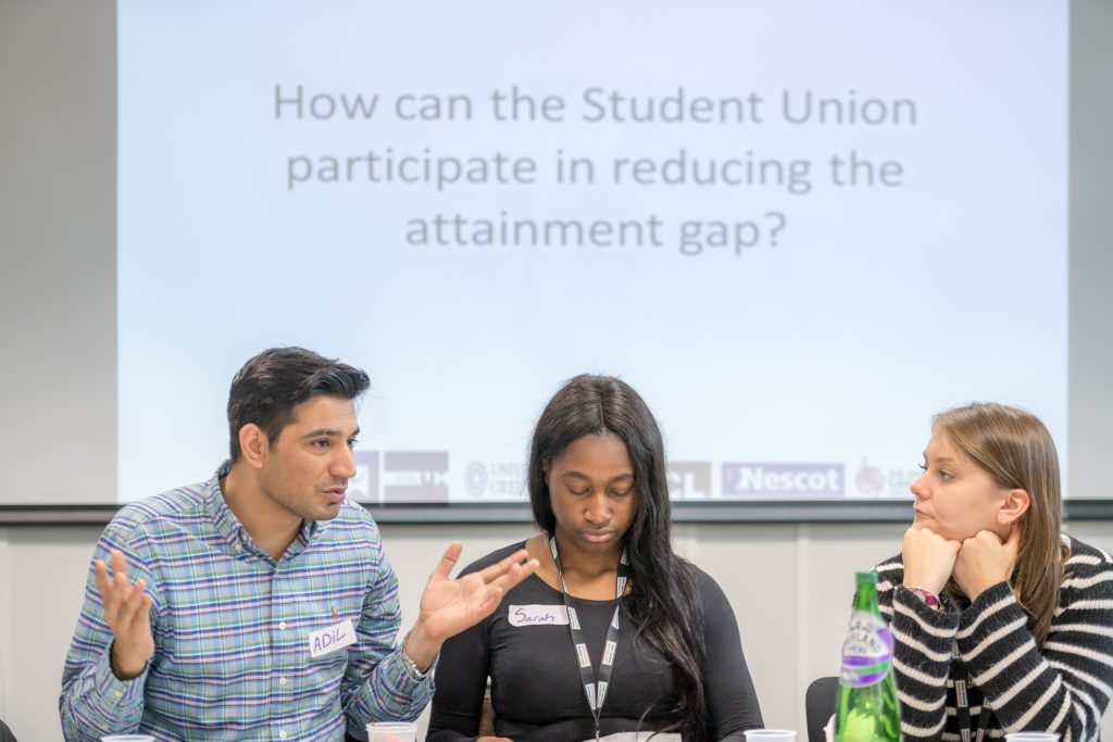 Three students sitting in front of a presentation.